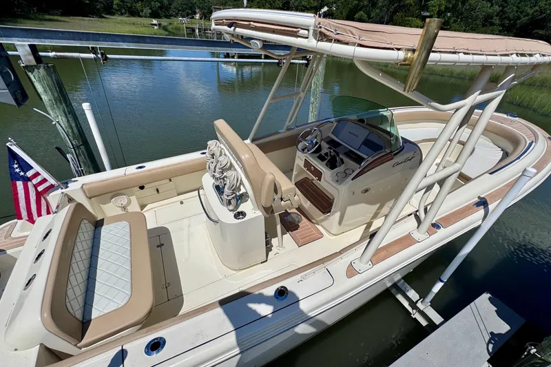 Slide: The Image of 2015 Chris-Craft Catalina 26 boat with elegant seating and helm, docked by the water. - 6