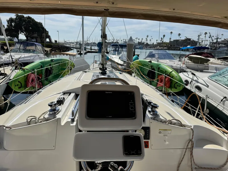 Slide: The Image of 2016 Marlow-Hunter 31 sailboat cockpit view in marina, surrounded by other boats. - 17