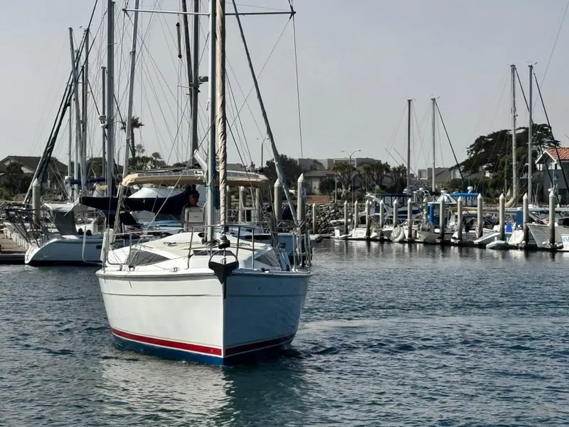 Slide: The Image of 2016 Marlow-Hunter 31 sailboat navigating a marina, surrounded by other boats and docks. - 3