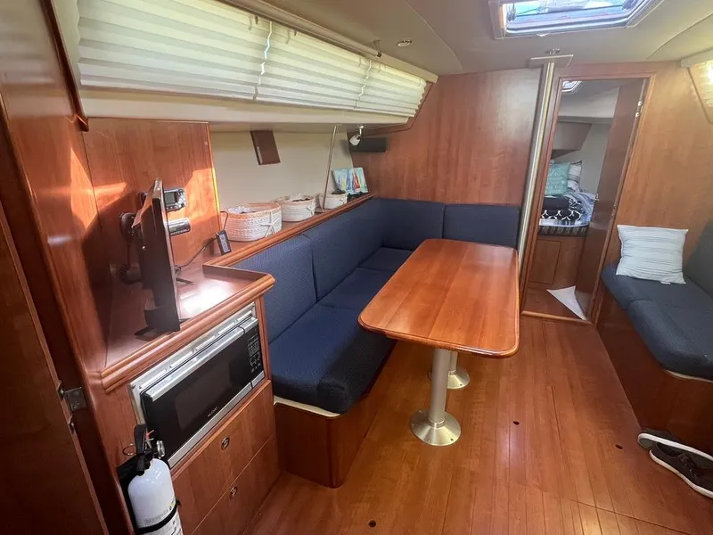 Slide: The Image of 2016 Marlow-Hunter 31 yacht interior with dining area, blue seating, and wood finish. - 9