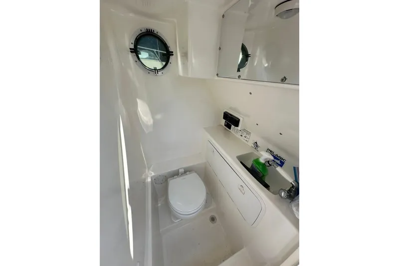 Slide: The Image of 2005 Marlago 35 SS boat bathroom with toilet, sink, and porthole window. - 17
