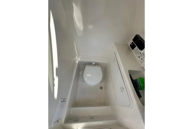 Slide: The Image of 2005 Marlago 35 SS boat interior with compact marine toilet and storage. - 19