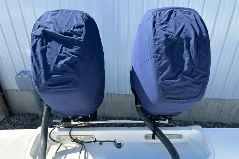 Slide: The Image of Covered outboard motors on a 2005 Marlago 35 SS boat, against a white wall background. - 30