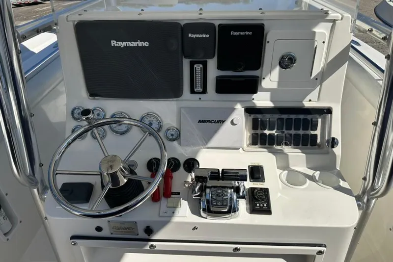 Slide: The Image of 2005 Marlago 35 SS boat dashboard with Raymarine electronics and Mercury controls. - 34