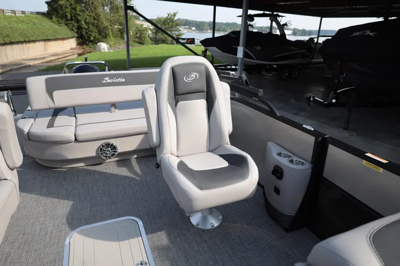 Slide: The Image of 2026 Barletta ARIA 22UC boat interior with plush seating and cup holders. - 11
