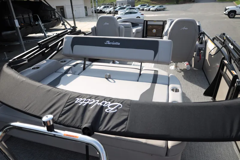 Slide: The Image of 2026 Barletta ARIA 22UC pontoon boat interior with seating and helm, parked outdoors. - 15