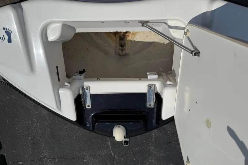 Slide: The Image of 2012 Yamaha Boats 242 Limited S storage compartment, open and empty, with visible latch mechanism. - 19