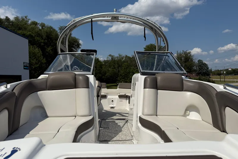 Slide: The Image of 2012 Yamaha Boats 242 Limited S interior with plush seating and open deck under blue sky. - 4