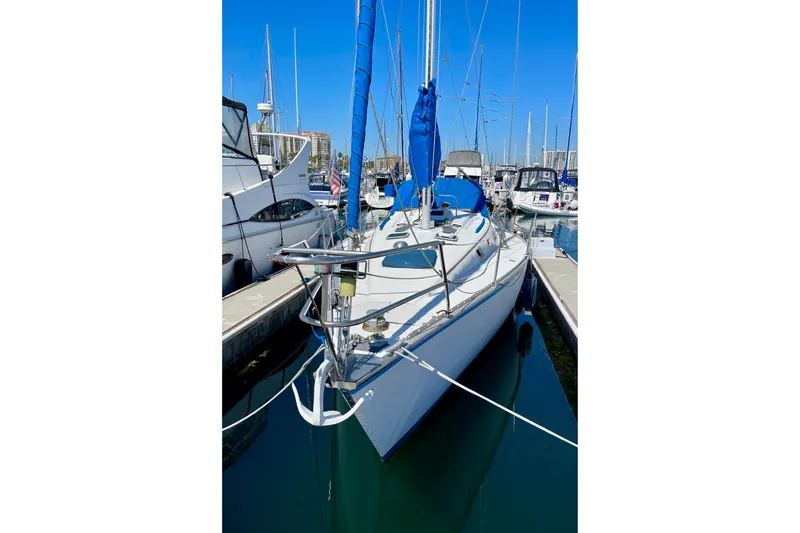 Slide: The Image of 1984 Hunter 34 sailboat docked in marina, featuring blue sail cover and sleek design. - 3