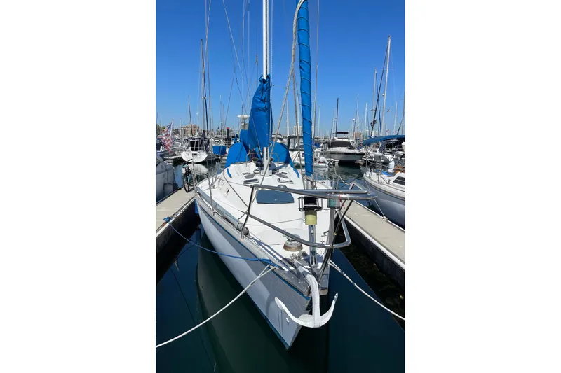 Slide: The Image of 1984 Hunter 34 sailboat docked in marina, featuring blue sail cover. - 4