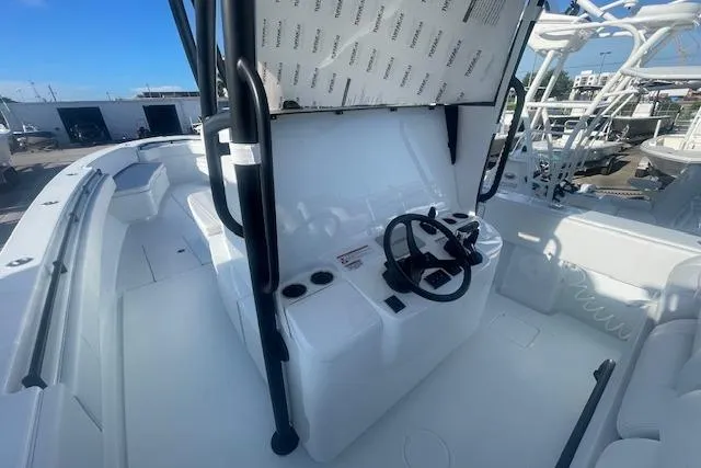 Slide: The Image of 2026 Contender 39 ST boat cockpit with steering wheel and seating, docked under clear blue sky. - 11