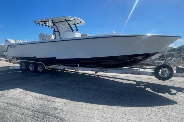 Slide: The Image of 2026 Contender 39 ST boat on trailer under clear blue sky. - 2