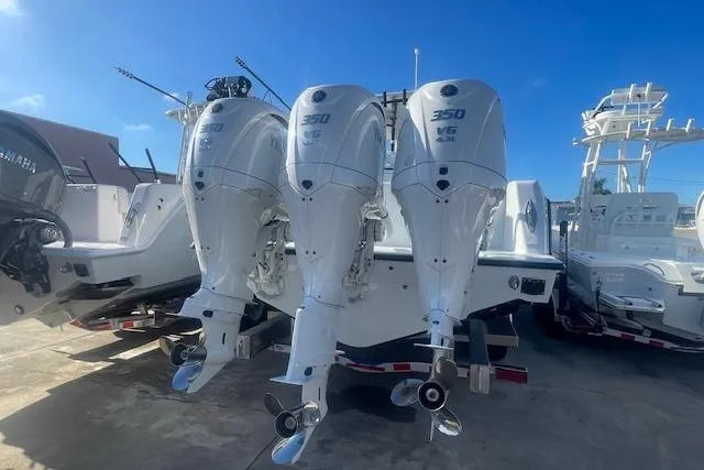 Slide: The Image of 2026 Contender 39 ST boat with triple 350 V6 outboard engines, docked under clear blue sky. - 4