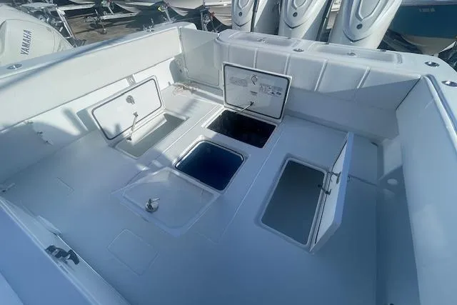 Slide: The Image of 2026 Contender 39 ST boat deck with open storage compartments and Yamaha engines. - 8