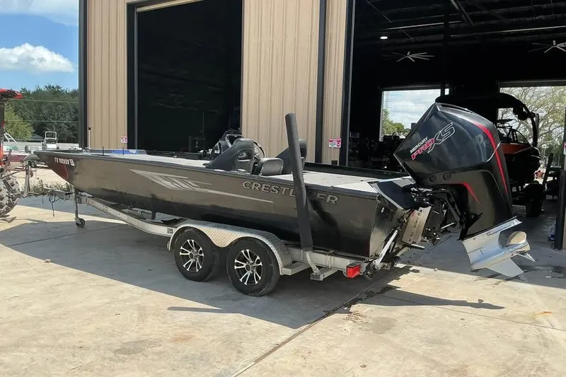 Slide: The Image of 2022 Crestliner MX 21 boat on trailer, parked outside a garage. - 3