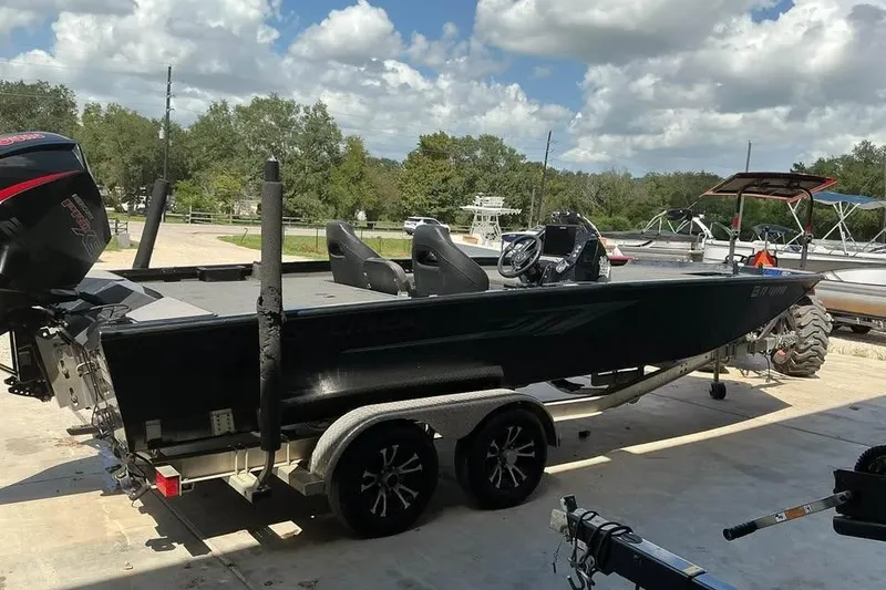 Slide: The Image of 2022 Crestliner MX 21 boat on trailer, parked outdoors under a partly cloudy sky. - 5