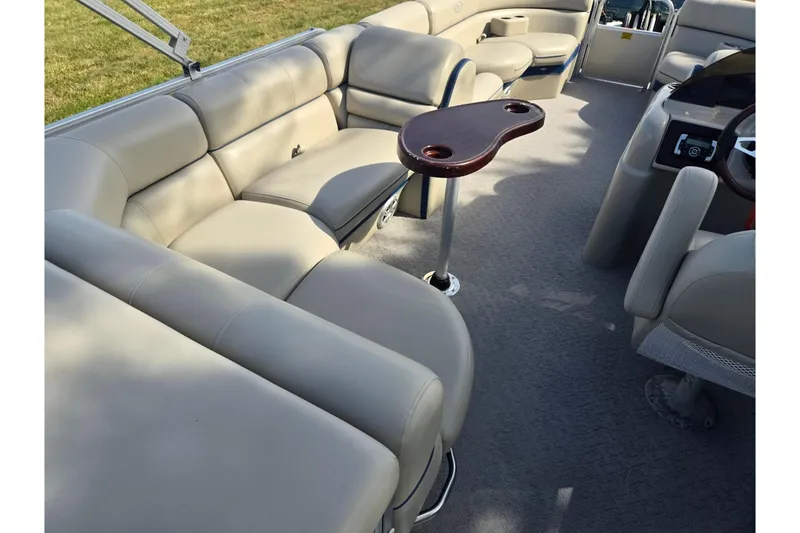 Slide: The Image of 2014 South Bay 522 FCR pontoon boat interior with beige seating and table. - 21
