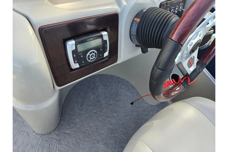 Slide: The Image of 2014 South Bay 522 FCR boat dashboard with steering wheel and Clarion audio system. - 23