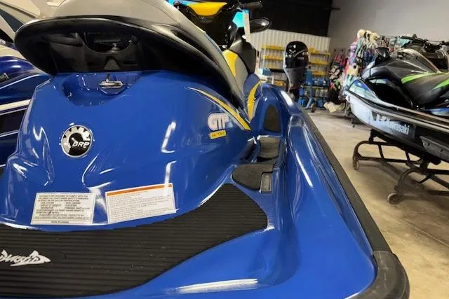 Slide: The Image of 2006 Sea-Doo GTI SE jet ski in a showroom, blue and yellow design. - 11