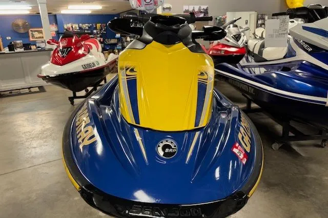 Slide: The Image of 2006 Sea-Doo GTI SE jet ski in showroom, blue and yellow design. - 2