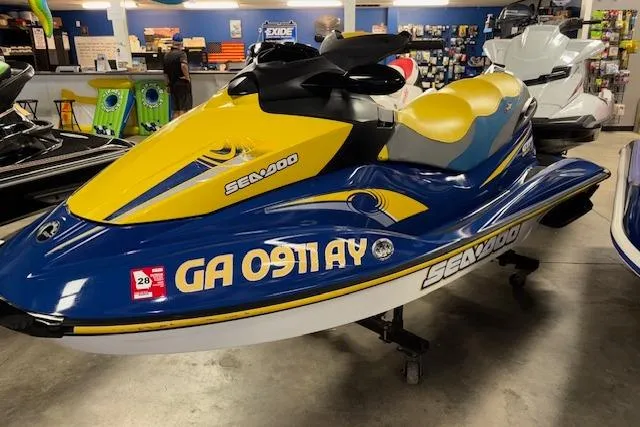 Slide: The Image of 2006 Sea-Doo GTI SE jet ski in showroom, blue and yellow design. - 3