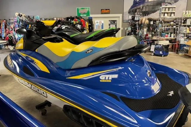 Slide: The Image of 2006 Sea-Doo GTI SE jet ski in showroom, blue and yellow design. - 7