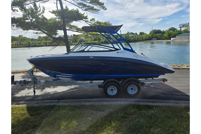 Slide: The Image of 2020 Yamaha Boats AR210 on trailer by a scenic waterfront. - 10