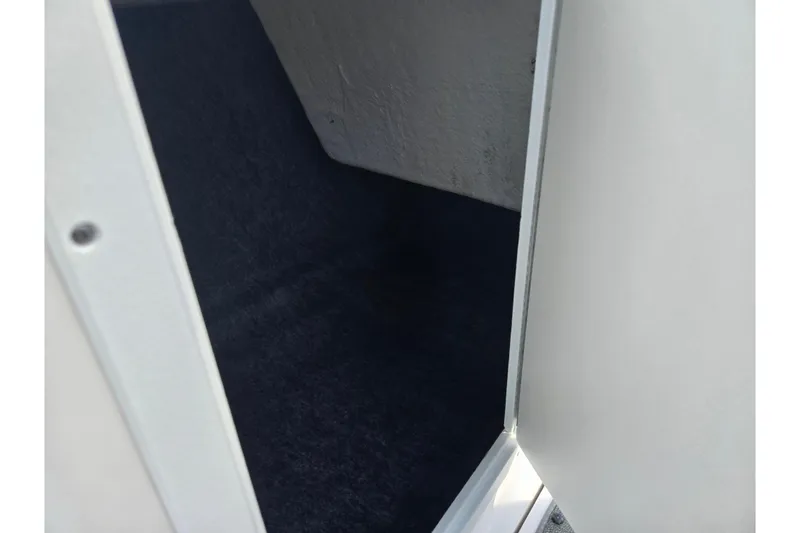 Slide: The Image of Storage compartment inside 2020 Yamaha AR210 boat, featuring dark interior and white door. - 17