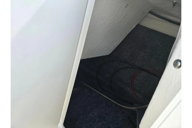 Slide: The Image of Interior storage compartment of 2020 Yamaha AR210 boat with visible wiring. - 18