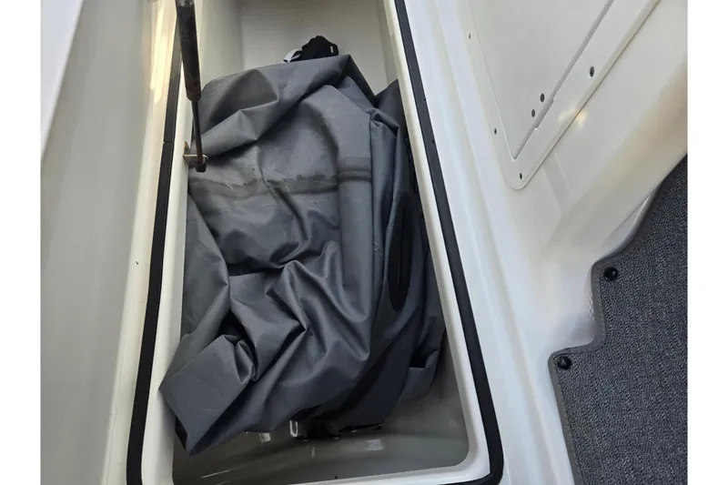 Slide: The Image of Storage compartment of a 2020 Yamaha AR210 boat with a gray cover inside. - 19