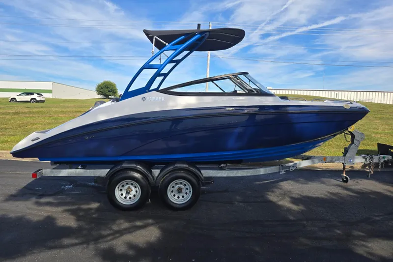 Slide: The Image of 2020 Yamaha Boats AR210 on trailer, blue and white, parked outdoors under clear sky. - 4