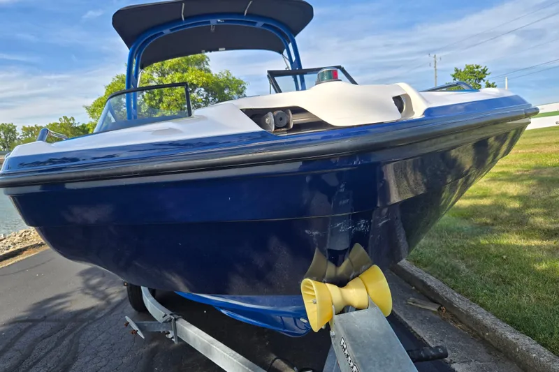 Slide: The Image of 2020 Yamaha Boats AR210 on trailer, blue hull, parked outdoors. - 7