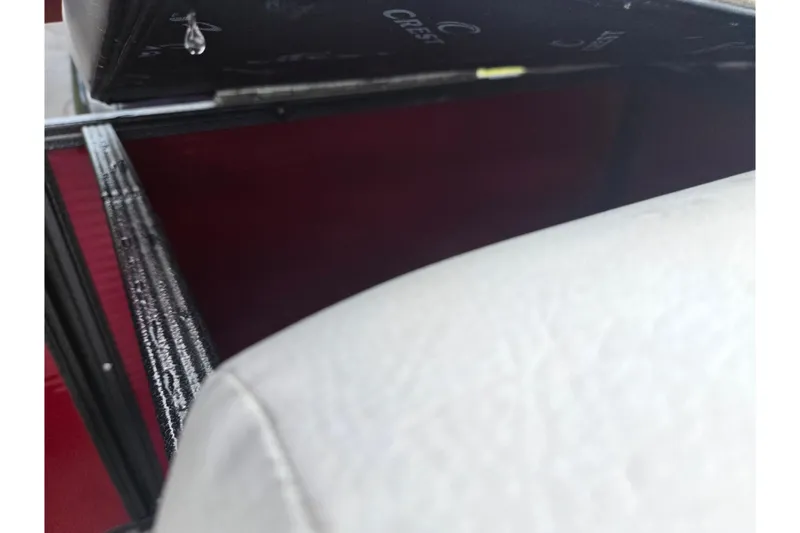 Slide: The Image of Open storage compartment in 2022 Crest Classic LX 220 boat, featuring red interior and white upholstery. - 17