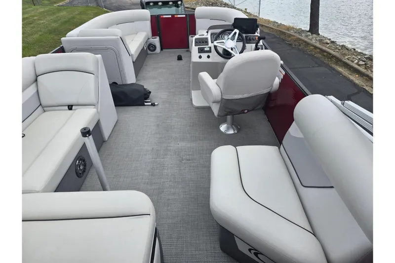 Slide: The Image of 2022 Crest Classic LX 220 pontoon boat interior with plush seating and steering console. - 20
