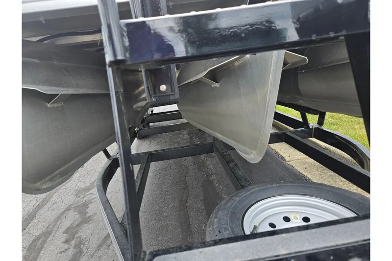 Slide: The Image of 2022 Crest Classic LX 220 pontoon boat underside on trailer, showing pontoons and wheel. - 7