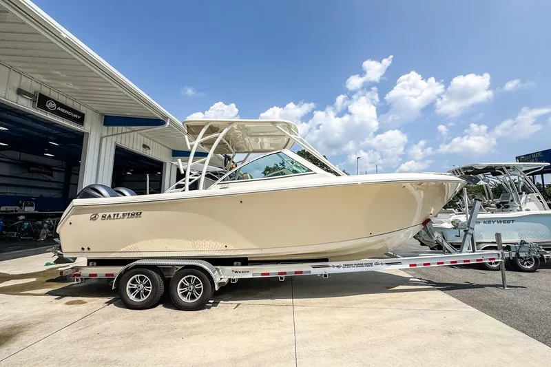The Image of 2018 Sailfish 275 DC boat on trailer, parked outside a marine service center. - 0
