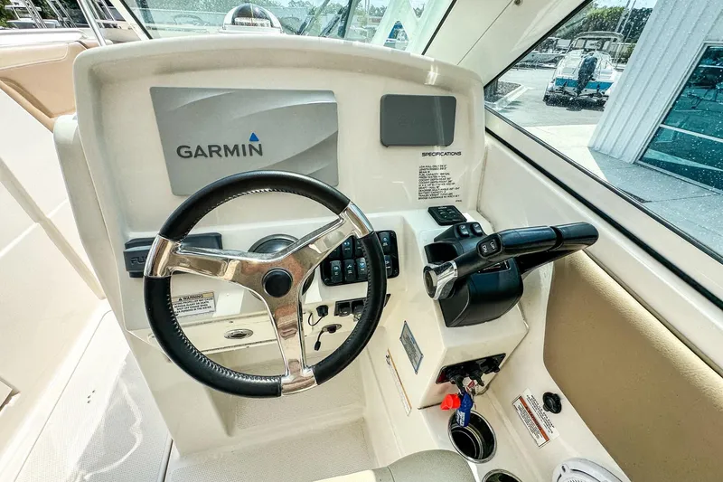 Slide: The Image of 2018 Sailfish 275 DC boat helm with Garmin navigation system and steering wheel. - 11