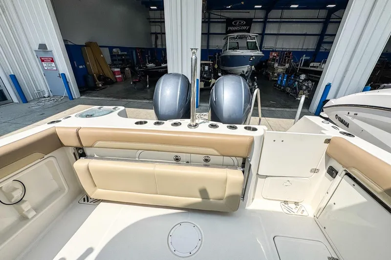 Slide: The Image of 2018 Sailfish 275 DC boat interior with dual engines in a marina setting. - 6