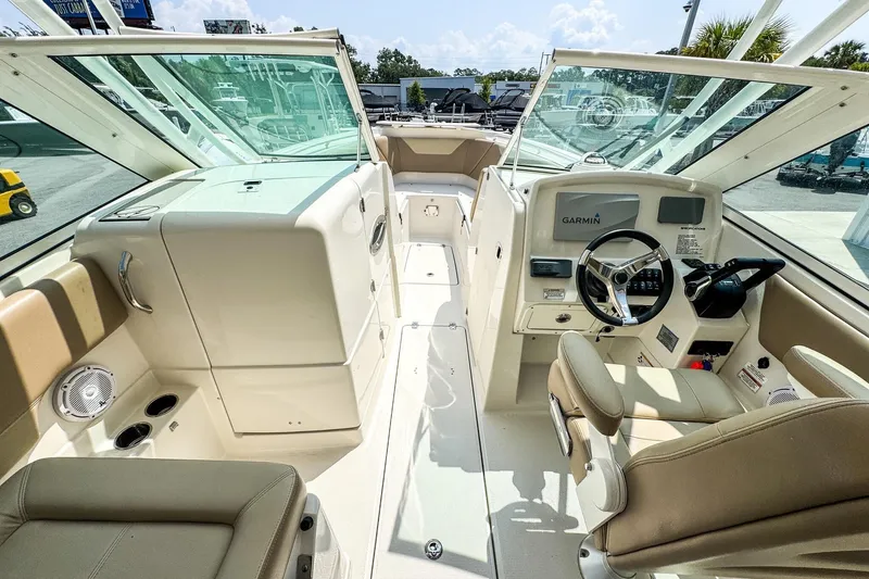 Slide: The Image of 2018 Sailfish 275 DC boat interior with Garmin navigation system and beige seating. - 8