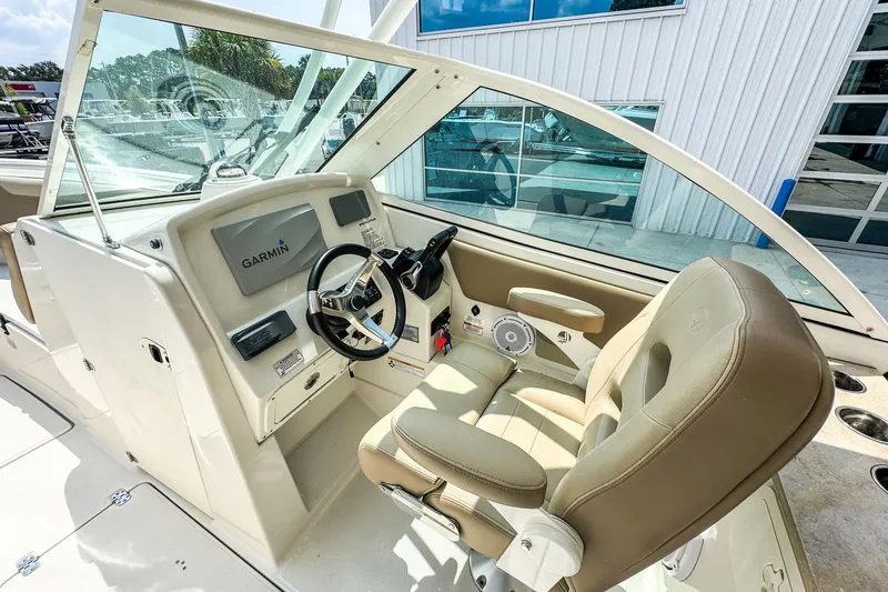 Slide: The Image of 2018 Sailfish 275 DC boat cockpit with Garmin navigation system and beige seating. - 9