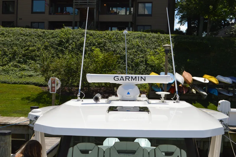 Slide: The Image of 2024 Tiara Yachts 34 LS with Garmin radar, docked near kayaks and greenery. - 28