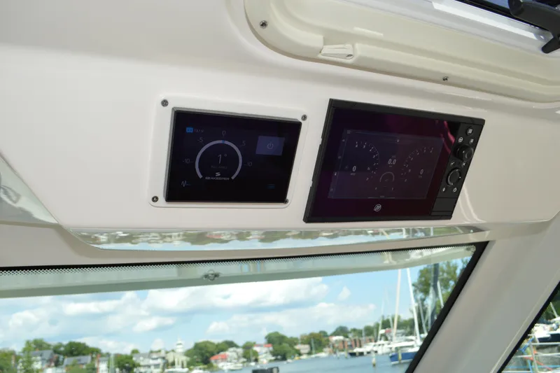 Slide: The Image of 2024 Tiara Yachts 34 LS dashboard with digital displays and scenic marina view. - 33