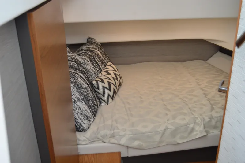 Slide: The Image of 2024 Tiara Yachts 34 LS cabin interior with cozy bed and patterned pillows. - 39