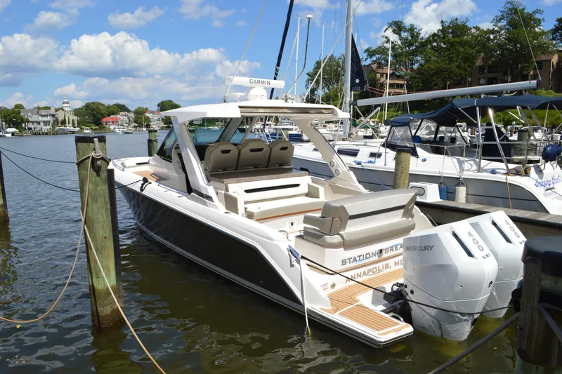 Slide: The Image of 2024 Tiara Yachts 34 LS docked, featuring dual Mercury engines, in a scenic marina setting. - 6