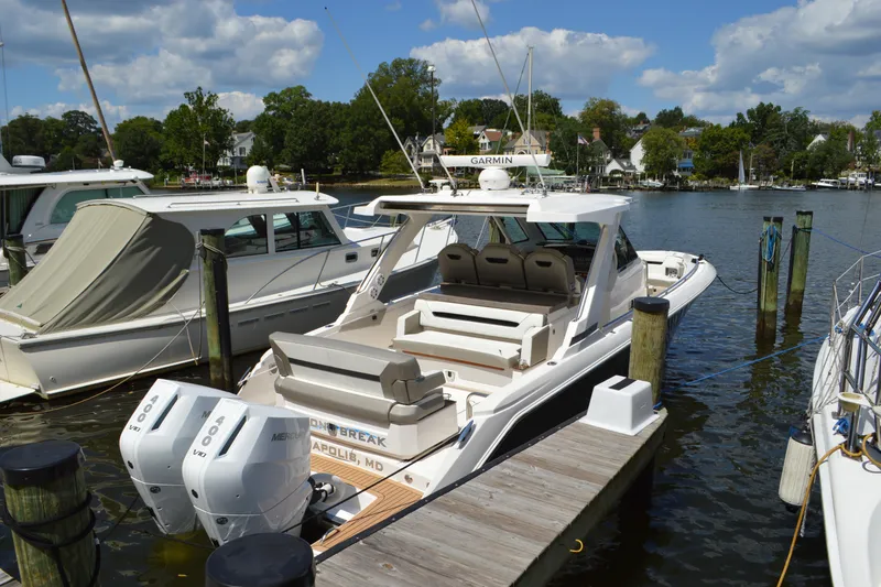Slide: The Image of 2024 Tiara Yachts 34 LS docked, featuring dual Mercury outboard engines, under a partly cloudy sky. - 7