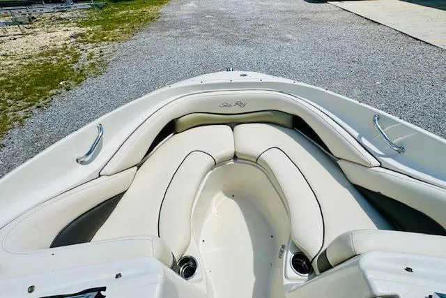 Slide: The Image of 2005 Sea Ray 200 Select boat interior with beige seating and dashboard, parked outdoors. - 10