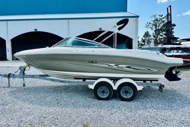 Slide: The Image of 2005 Sea Ray 200 Select boat on trailer, parked outdoors under clear blue sky. - 3
