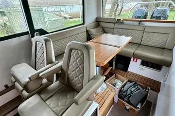 Slide: The Image of 2018 Axopar 37 XC CROSS CABIN interior with leather seating and wooden table. - 14