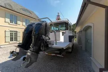 Slide: The Image of 2018 Axopar 37 XC CROSS CABIN with dual outboard motors in a driveway. - 26