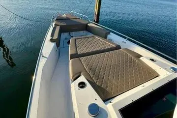 Slide: The Image of 2018 Axopar 37 XC CROSS CABIN boat with cushioned seating on calm water. - 6